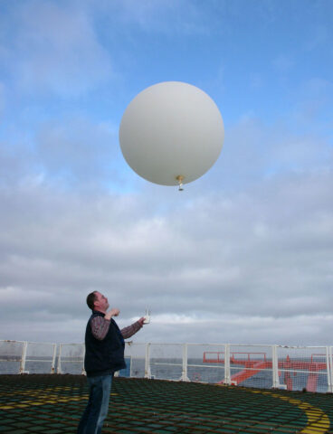 Release of a radiosonde, attached to a helium-filled balloon, on the helicopter deck of the research vessel Polarstern. The radiosonde seen here measured temperatures, wind speeds and ozone concentrations along a profile up to an altitude of 20 kilometers. Credit: Hannes Grobe, CC BY-SA 2.5