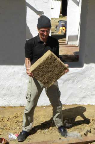 Brian Tucker of GeoHazards International (GHI) struggling to hold a heavy adobe brick used in typical buildings in rural Peru. GHI retrofitted an adobe school building in the village of Chocos, Peru, with geomesh, which holds the adobe walls together and greatly improves their earthquake resistance. Nepal has similarly vulnerable brick and stone masonry buildings. Credit: Gregory Deierlein, Stanford University