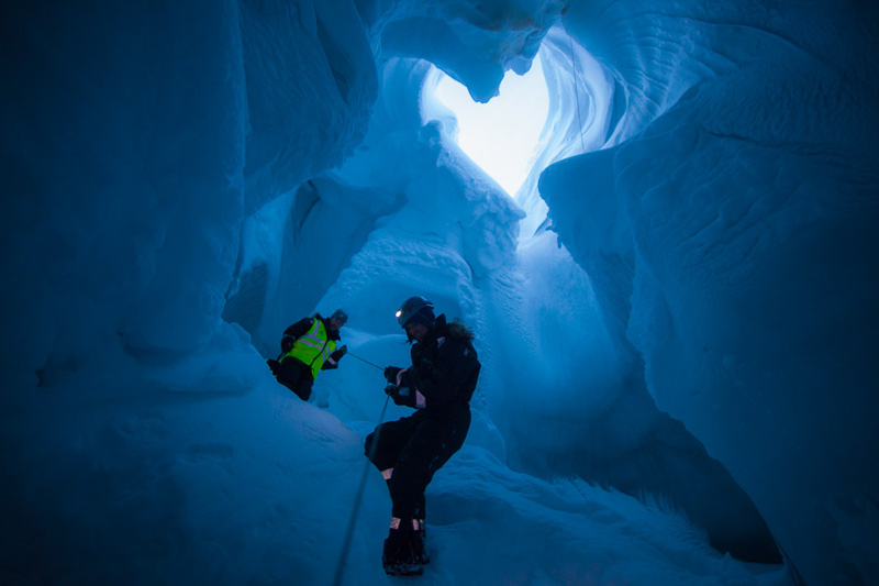 Riverman’s ice caving colleagues climb down into the cave.