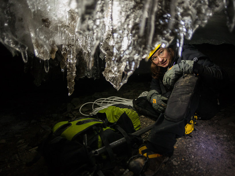 Kiya Riverman peers at ice crystals growing from the ceiling of an ice cave in the Larsbreen glacier in Svalbard, Norway.