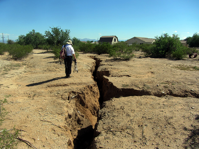 Michael Conway, chief of the Geologic Extension Service at the Arizona Geological Survey, maps Earth fissures in the Queen Creek area south of Phoenix, Ariz.