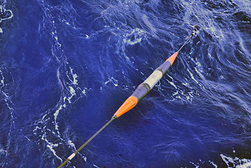 An optical repeater slips beneath the waves as the cable it is attached to is deployed along the ocean floor.