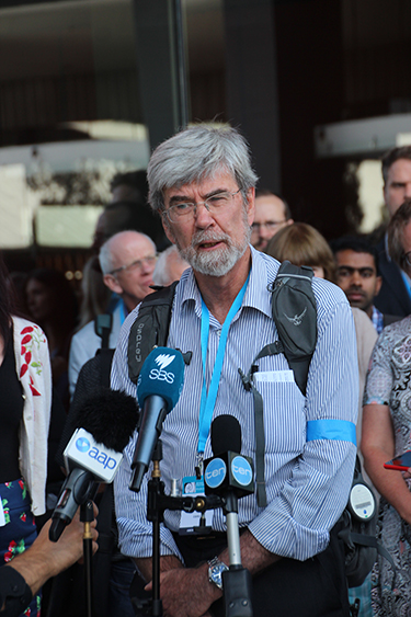 John Church gives a media interview as a part of a lunchtime protest at a climate science conference in Melbourne.