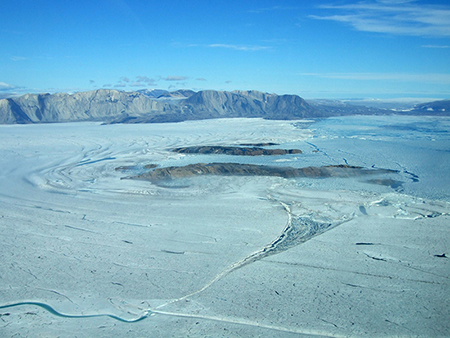 Aerial view, looking north over the front of Nioghalvfjerdsbræ (79°30’N, 19°30’W). Nioghalvfjerdsbræ and its southern neighbor, Zachariae Isstrøm, form the major outlet glaciers of the Northeast Greenland Ice Stream. Credit: Mirko Scheinert