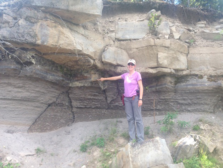Christy Till points at an ash layer in the Lava Creek tuff, which deposited during Yellowstone’s most recent supereruption.