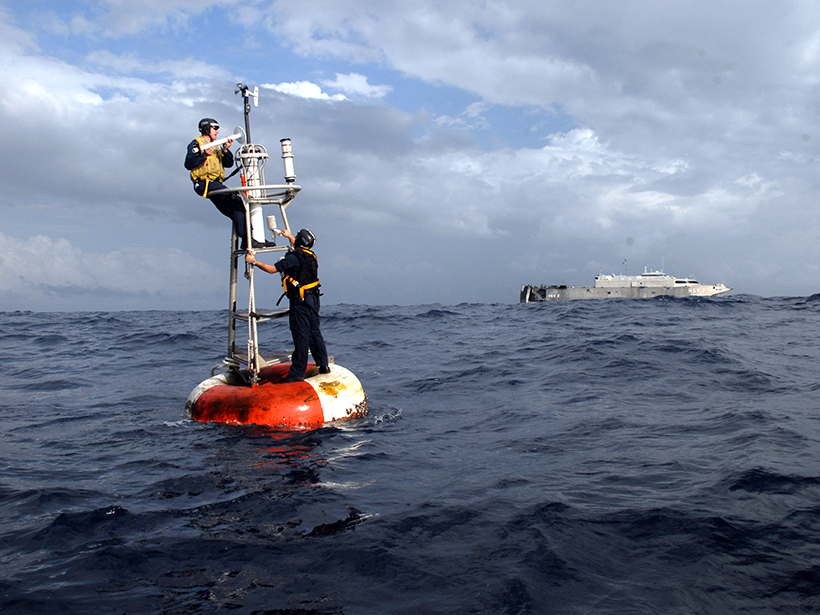 U.S. Navy sailors repair NOAA weather instrument.