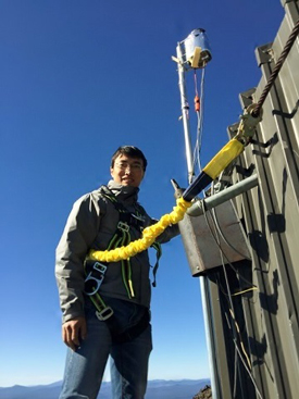 Researcher Lei Zhang wears a harness to access equipment at the Mount Bachelor Observatory.