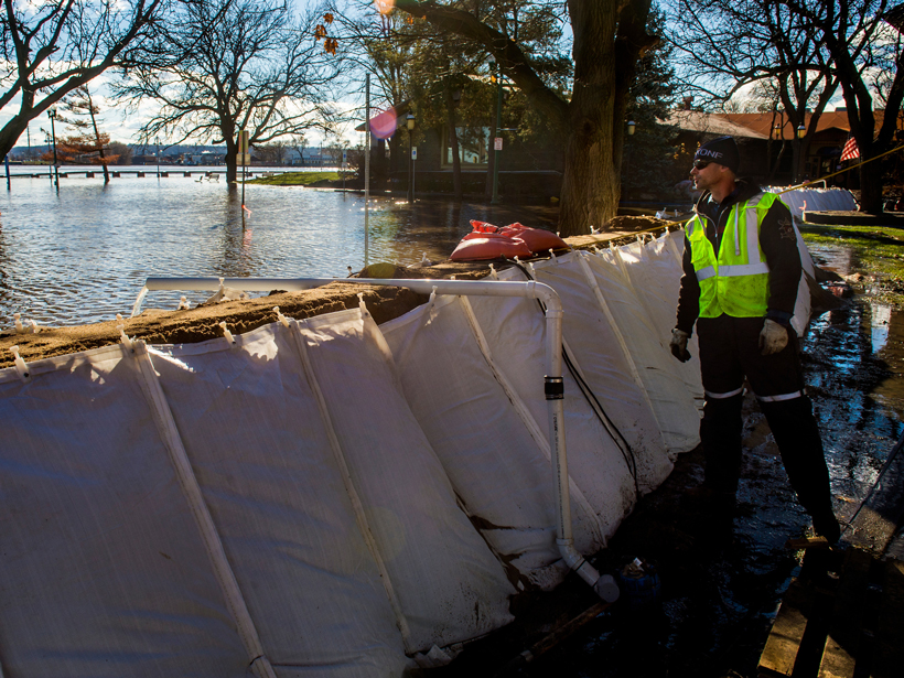 A city employee checks on the pumps as a sandbag wall keeps flood waters from the Illinois River at bay in January 2016.