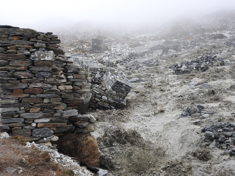 A glacial outburst flood from Lhotse Glacier on 12 June 2016 threatens a stone wall adjacent to a village in Nepal.