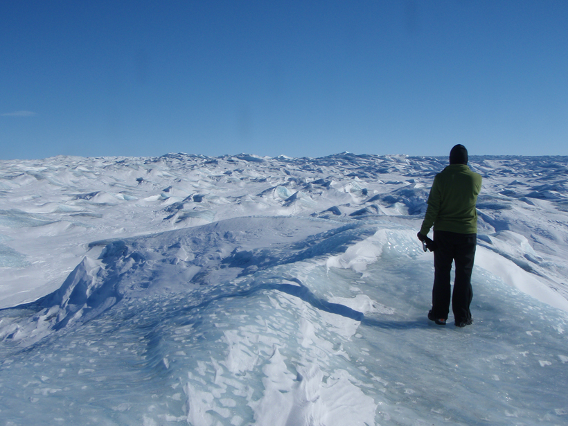 A researcher looks over the Greenland ice cap, a “frozen ocean.”