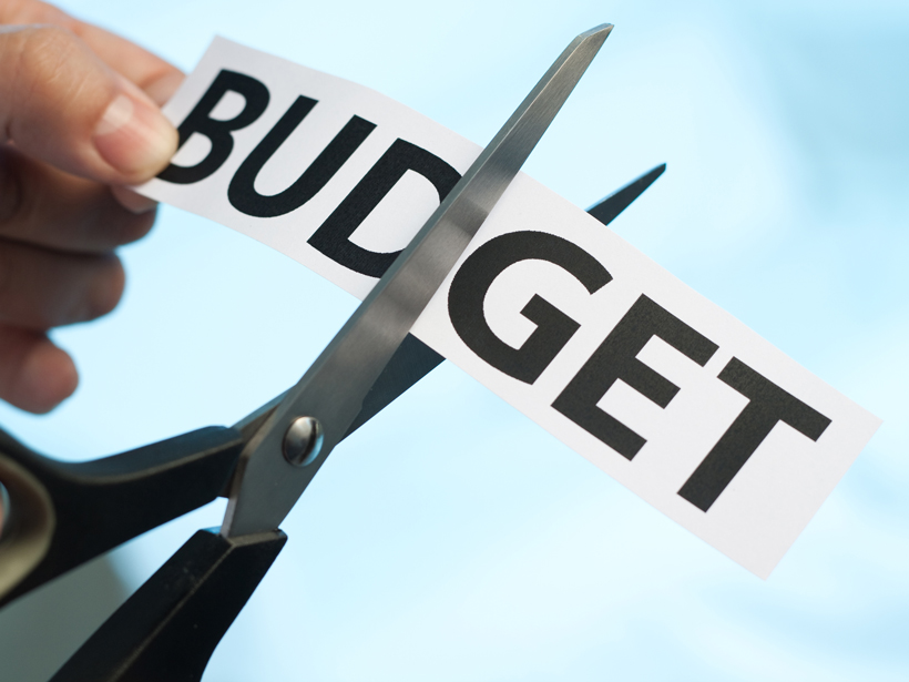 Scissors cutting the word "budget."