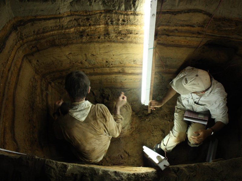 Using fluorescent lights to look for charcoal and shells in sediment layers in a cave in Indonesia to use to radiocarbon date tsunami deposits.