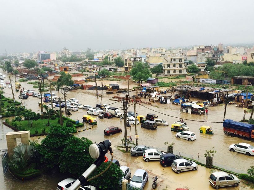 Residents of Palam Vihar in Gurgaon, Haryana, India, make their way through flooded streets after a typical monsoon spell