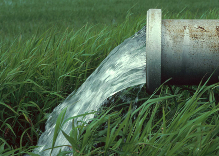 A water supply system releasing water into a field.
