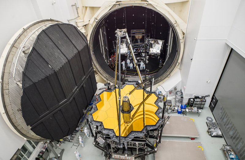 Engineers pose with the James Webb Space Telescope