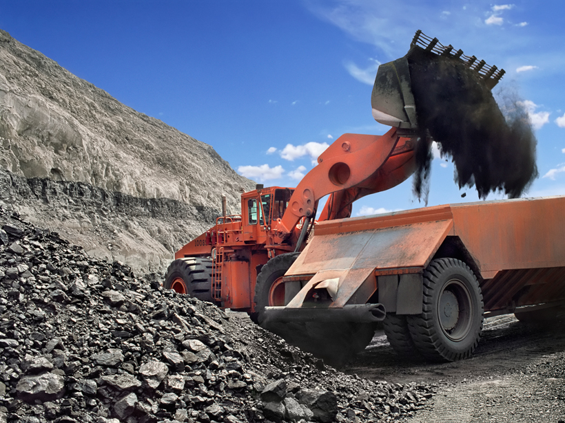 A bulldozer drops a load of freshly mined coal into a waiting truck outside of a mine in New Mexico.