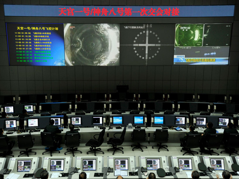 Scientists at a satellite launch center in China monitor the docking of a space lab module and a spacecraft in late 2011