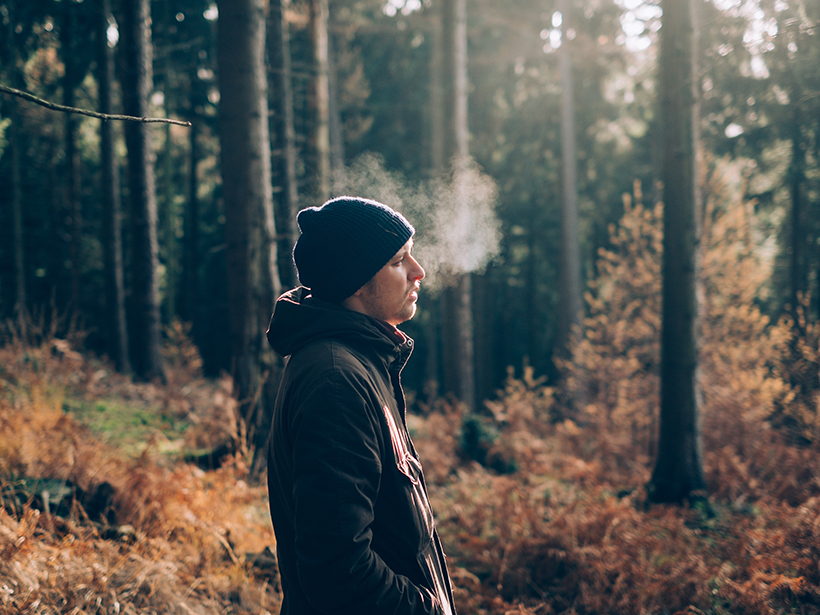 A man exhales in a forest