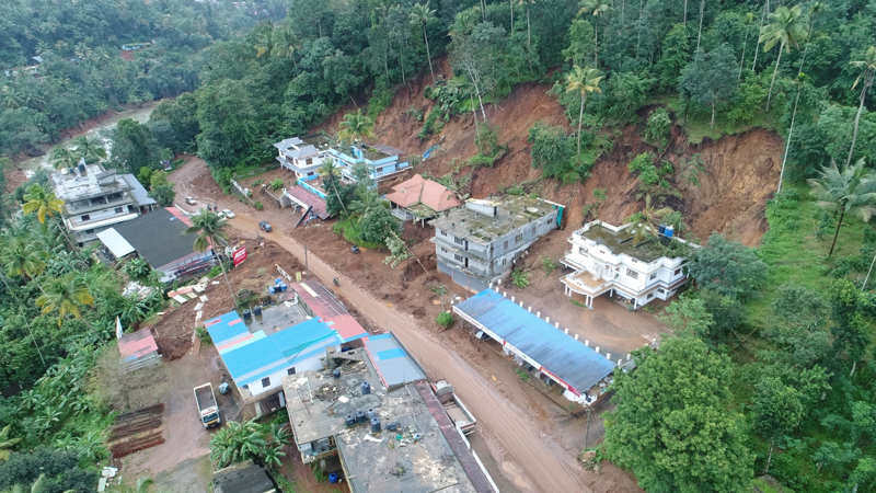Debris from a landslide stacked against homes in Idukki, India.