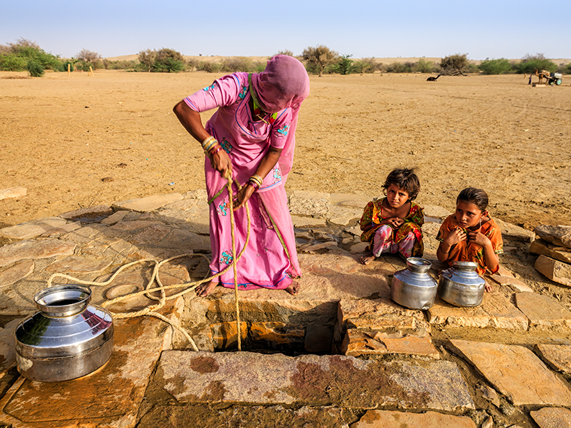 A woman draws water from a well in northern India, where unsustainable aquifers are vulnerable to drought conditions.