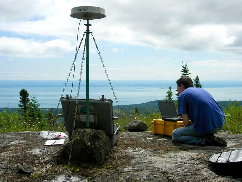 A scientist installs GPS equipment to monitor earthquakes.