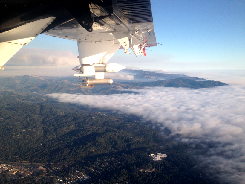 A Twin Otter turboprop flies over California, taking measurements of smoke from a wildfire.