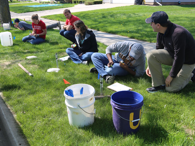 Researchers measure soil infiltration capacity outside a private residence
