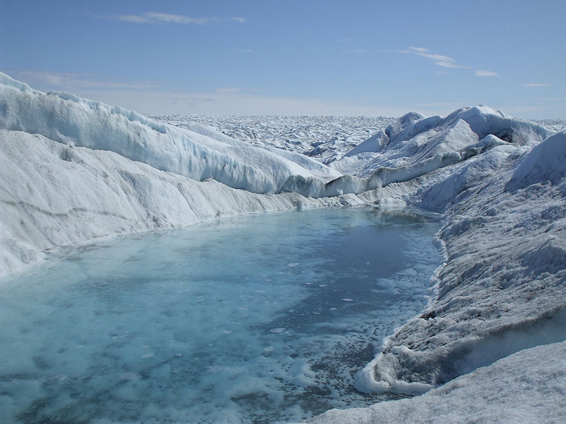 A pool of meltwater sits on a vast continental glacier.