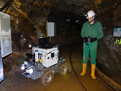 A man operates a rover in a mine shaft.