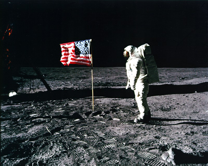 An astronaut faces the American flag on the Moon.