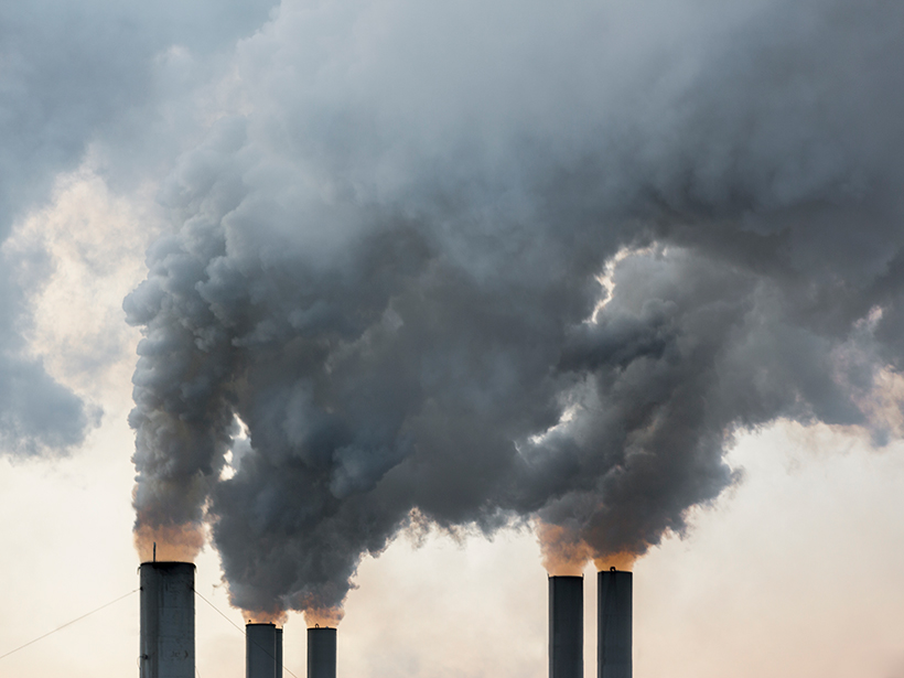 Plumes of smoke rise from industrial smokestacks.