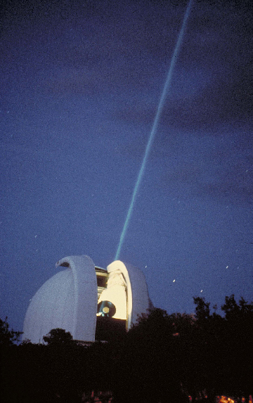 A laser beam shines out of an observatory.