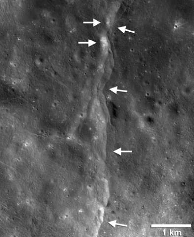 Black-and-white satellite image of the lunar landscape with arrows pointing to a ridge Black-and-white satellite image of the lunar landscape with arrows pointing to a ridge