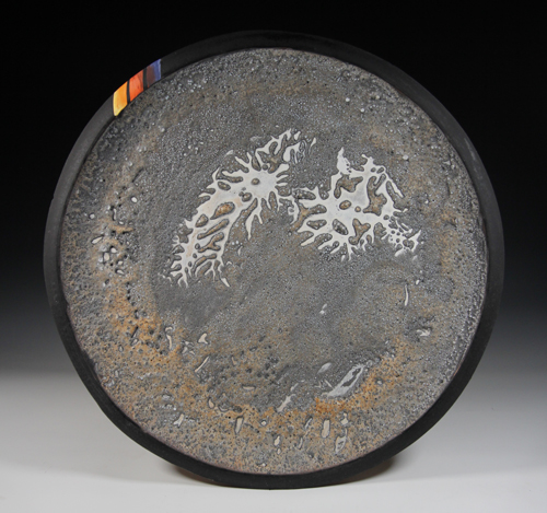 A ceramic platter coated with iron inspired by asteroid 16 Psyche