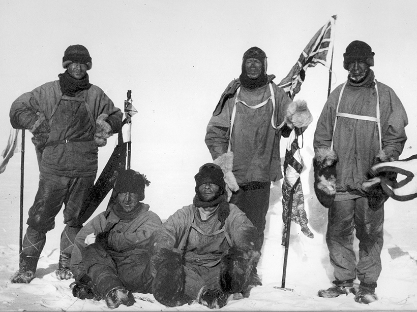 Black-and-white photo of unsmiling white explorers at the South Pole