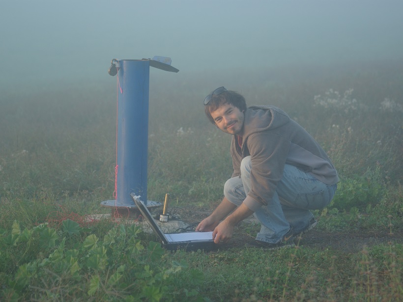 Scientist downloading groundwater level and barometric pressure data from a borehole