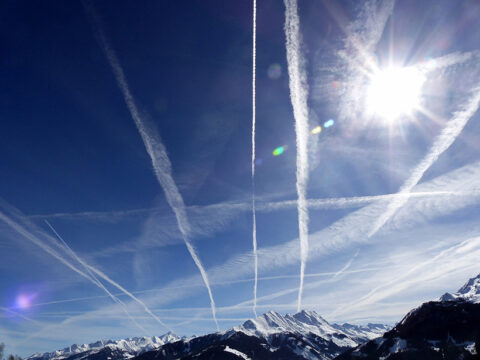 Airplane contrails over mountains