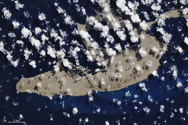Satellite image of a huge raft of floating grey rocks in the ocean