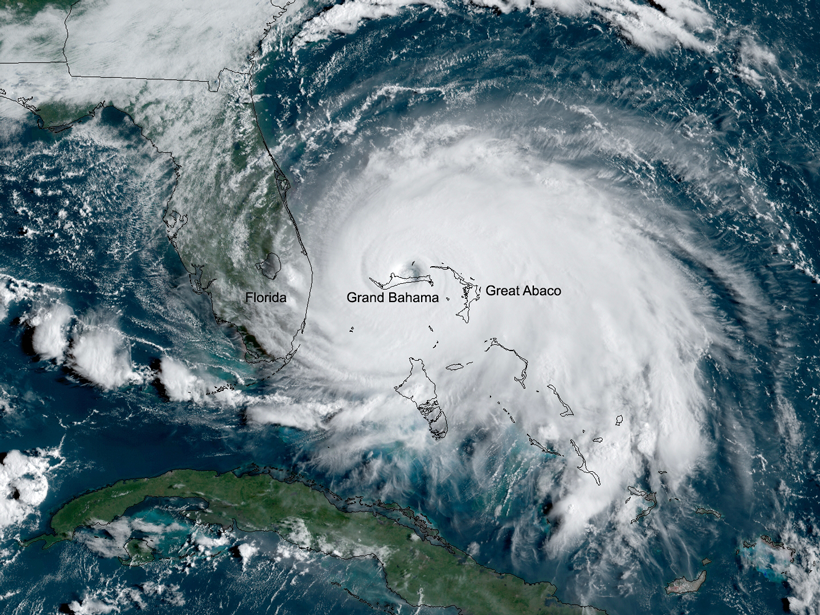 Satellite image of Hurricane Dorian stationary over marked outlines of Grand Bahama