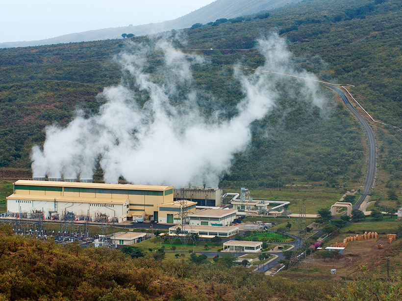 Photo of a geothermal power plant in green foothills