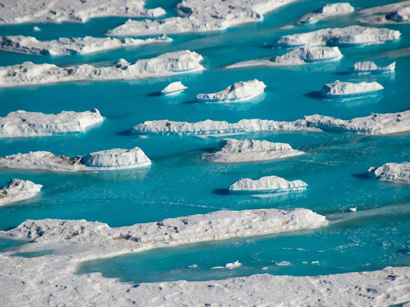 Pools of bright blue water amid ice