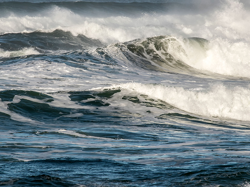 Crashing ocean waves create sea spray