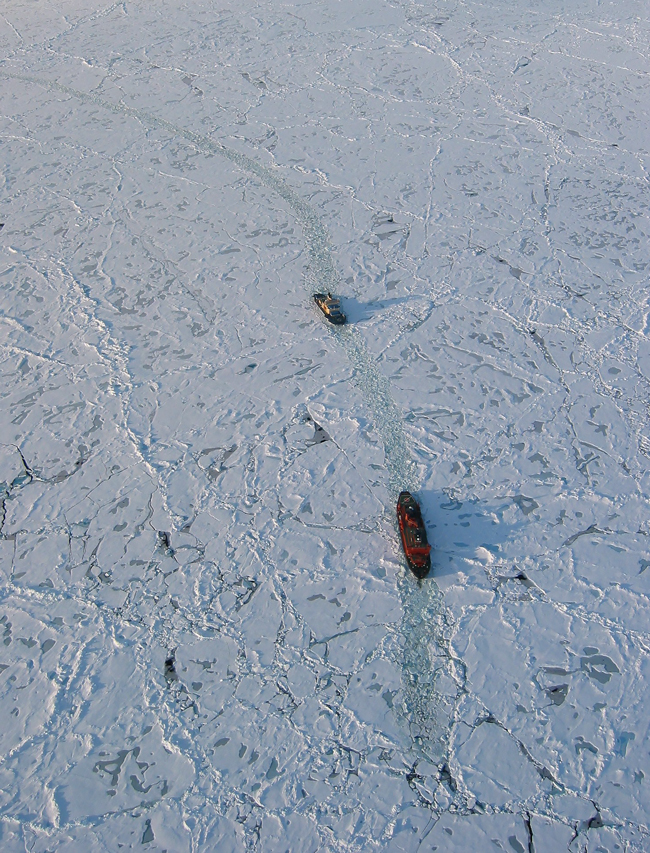 The smaller Swedish icebreaker Oden follows the Russian nuclear-powered icebreaker 50 Let Pobedy through heavy sea ice.