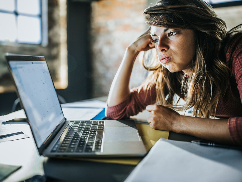 Bored woman looking at a calendar on her laptop