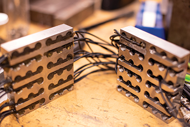 Acoustic sensors mounted in steel plates that detect sounds emitted during testing at Penn State’s earthquake machine. Acoustic sensors mounted in steel plates that detect sounds emitted during testing at Penn State’s earthquake machine.