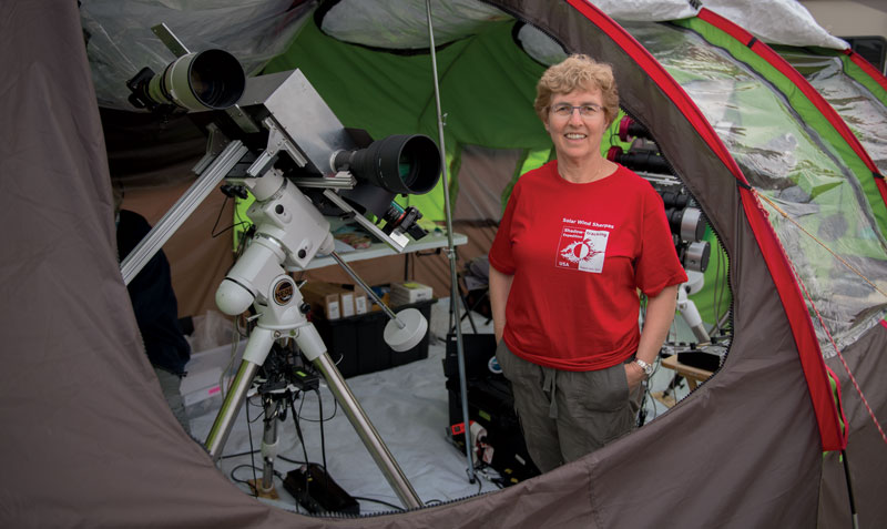 Photo of solar physicist Shadia Habbal inside a tent with a telescope