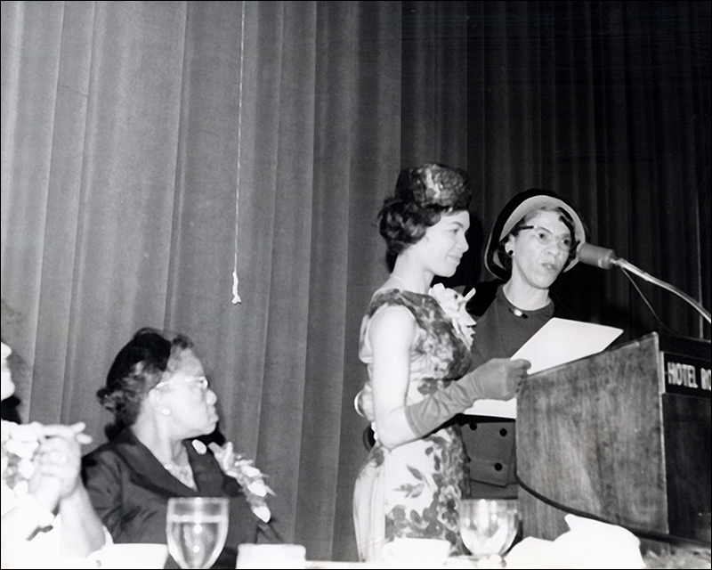 Black-and-white photo of two African American women standing at a podium on a dais Black-and-white photo of two African American women standing at a podium on a dais