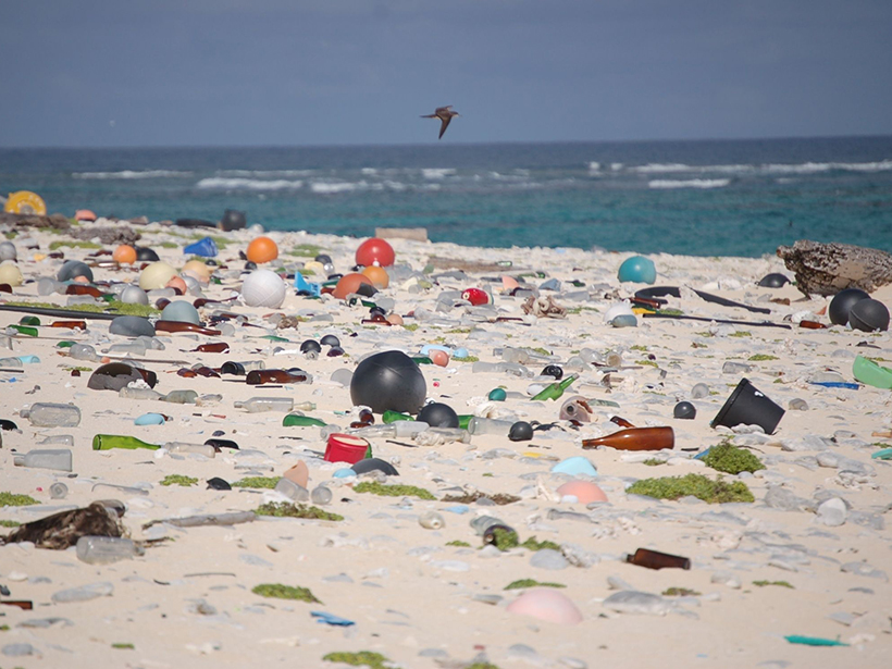 Beach strewn with plastic and glass debris