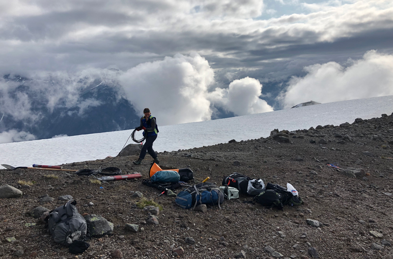 A member of a field team lays a sensor cable along a ridge to help collect magnetotelluric (MT) measurements. A member of a field team lays a sensor cable along a ridge to help collect magnetotelluric (MT) measurements.