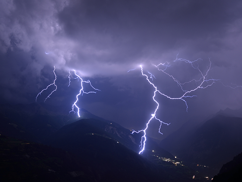 Bolts of lightning strike a Swiss valley at night